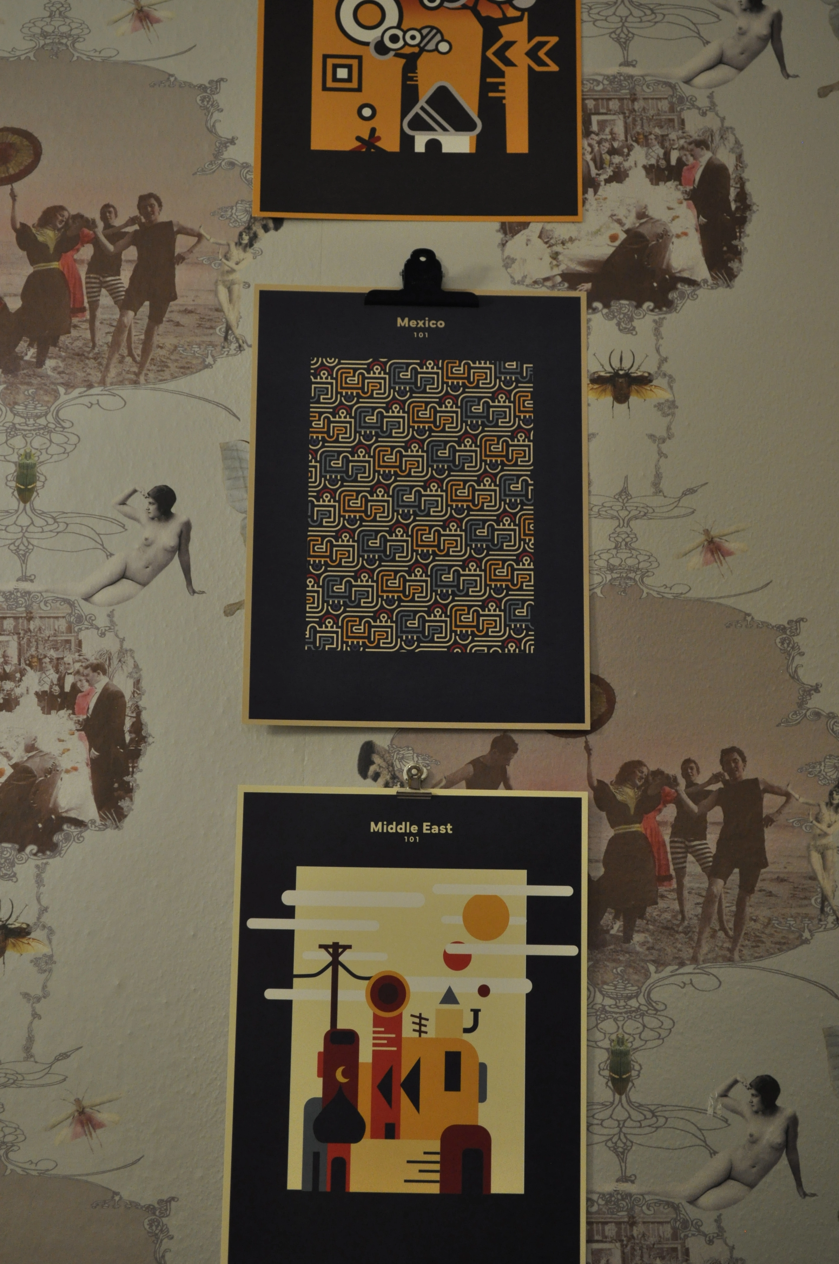 Three posters laying on a wall
